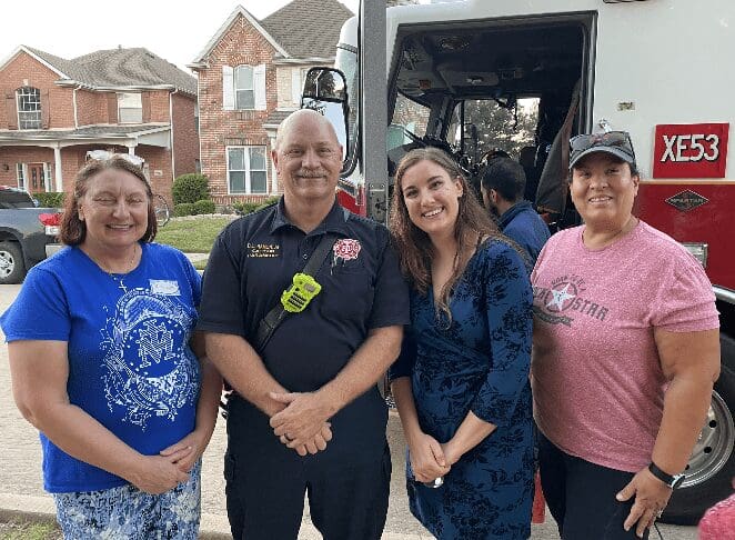 A group of people standing in front of a truck.