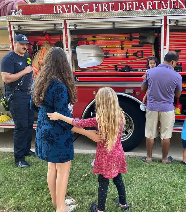 A group of people standing around a fire truck.