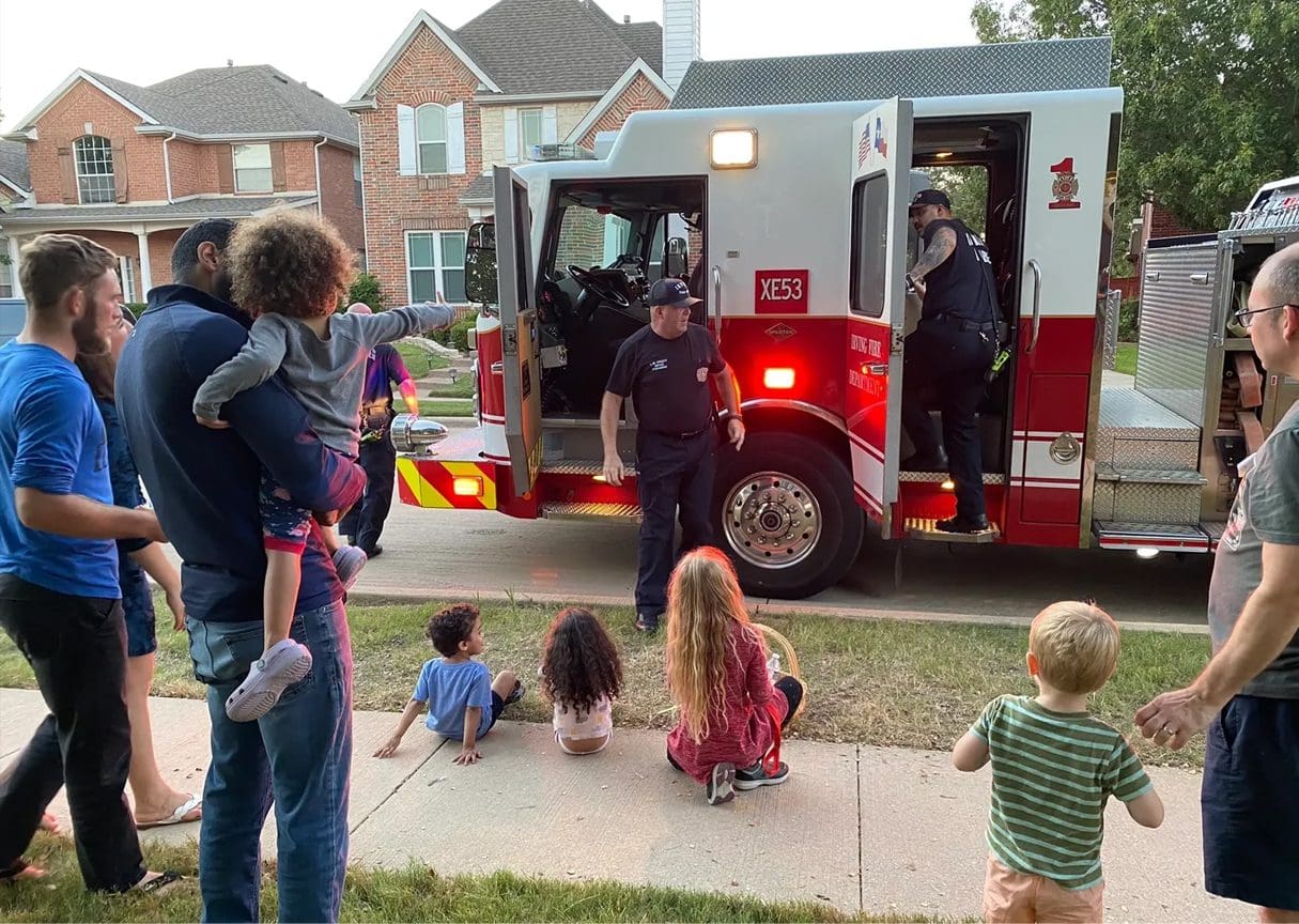 A group of people standing around a fire truck.